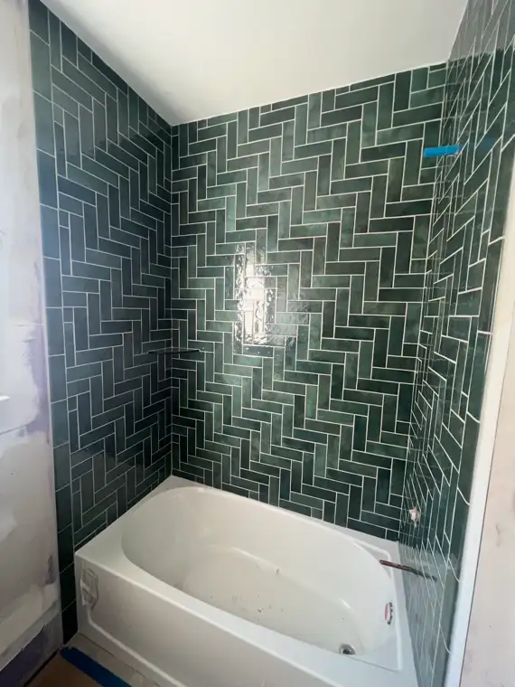 Green herringbone tile tub surround