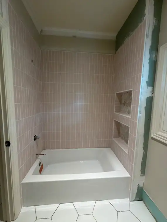Pink vertical tile tub surround with double niches