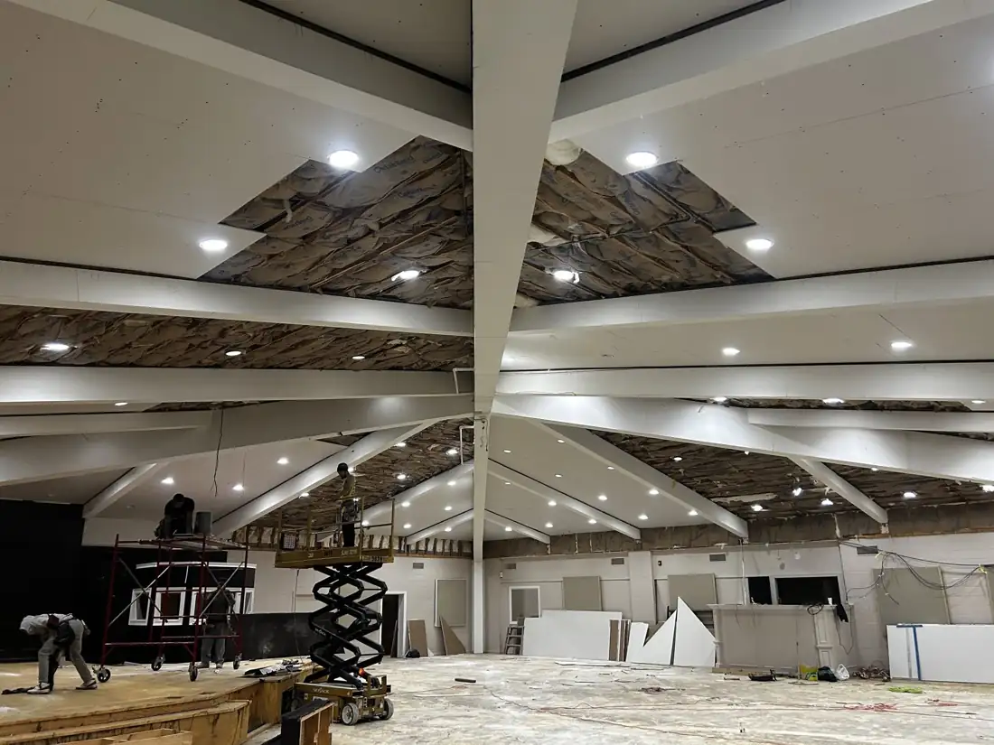 Commercial ceiling buildout in progress with scissor lift